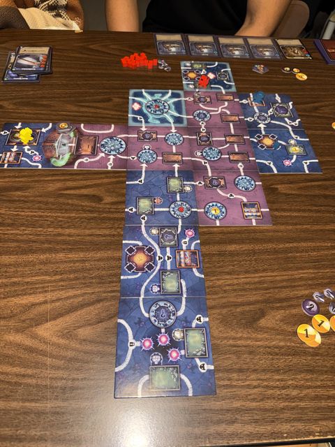 Explored dungeon tiles branching across the table, forming the board as players revealed new rooms